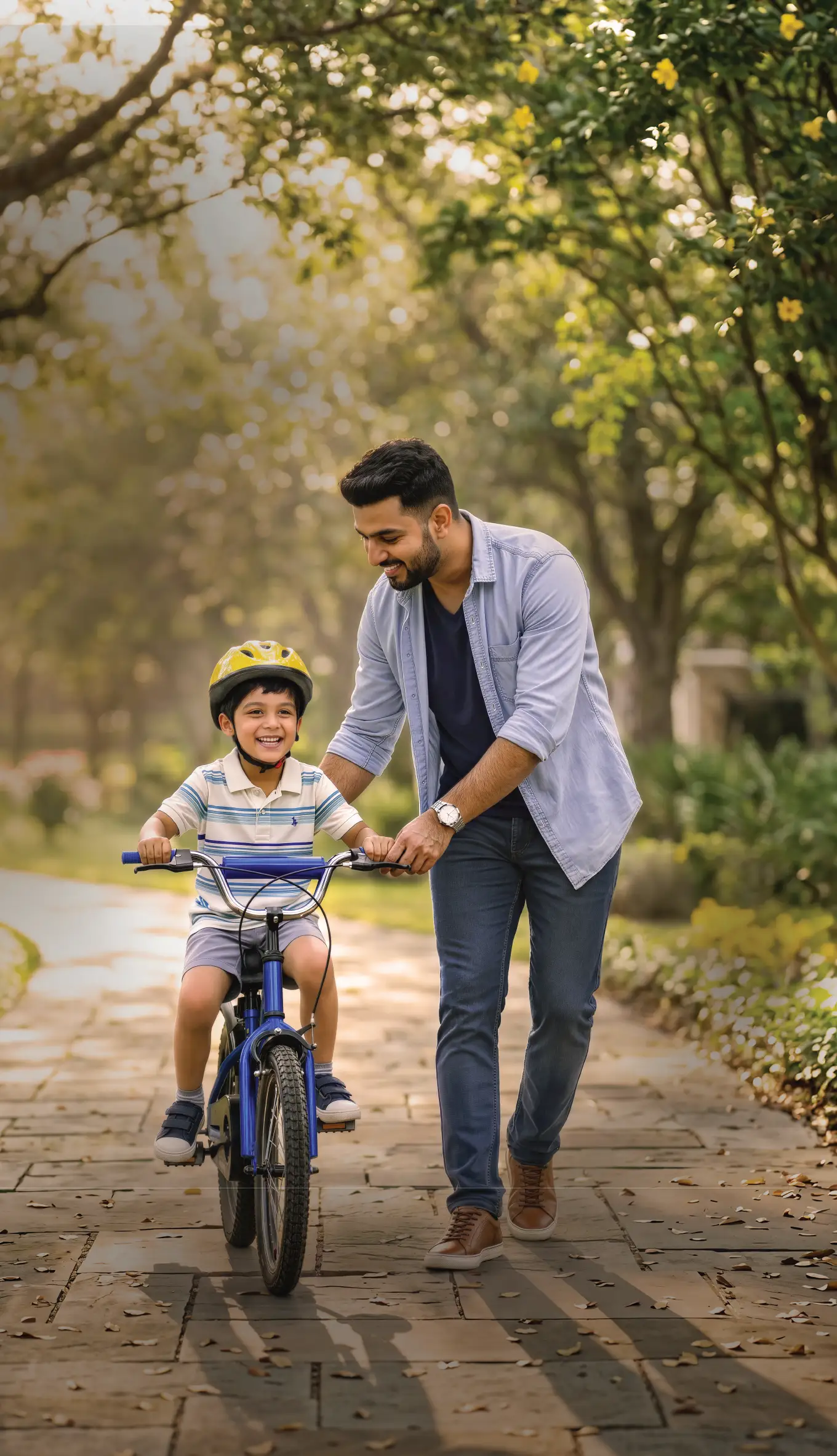 A father guiding his son on a bicycle in a lush park